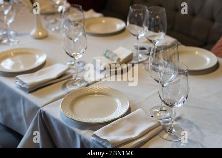 Wunderschön gedeckte Tische mit Gläsern und Geräten am Morgen im Restaurant Stockfoto