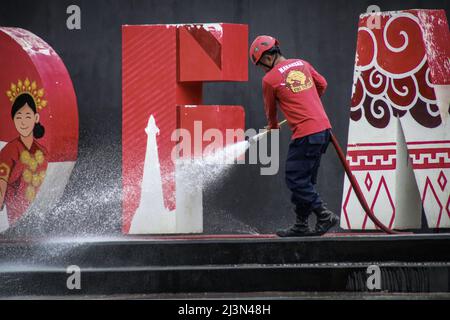 Makassar, Süd-Sulawesi, Indonesien. 9. April 2022. Feuerwehrmänner reinigen den Boden der Touristenattraktion Losari Beach Pavilion in Makassar, Provinz Süd-Sulawesi, Indonesien. Dieser Touristenort wird während des Ramadan sehr von Menschen besucht, zum Zeitpunkt des Fastenbrechens. (Bild: © Herwin Bahar/ZUMA Press Wire) Bild: ZUMA Press, Inc./Alamy Live News Stockfoto