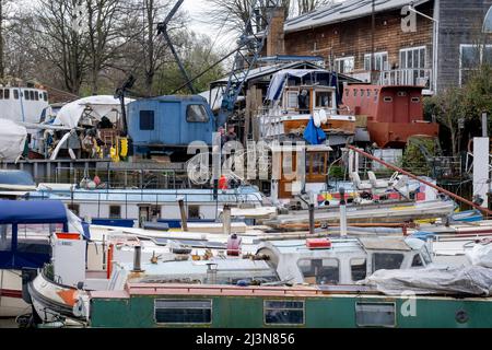 Vom gegenüberliegenden Ufer der Themse aus gesehen, wurden am 6.. April 2022 in London, England, verschiedene Boote und Flussschiffe auf einer Werft auf der Eel Pie Island Gemeinde gesehen. Stockfoto