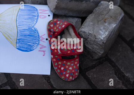 Kinderschuhe und die Flagge der Ukraine, der krieg in der Ukraine. Stockfoto