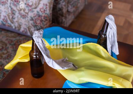 Molotow Cocktail, Kriegsrecht in der Ukraine, eine brennbare Mischung in Flaschen mit einem Lappen liegt auf der Flagge der Ukraine, Krieg Ukraine 2022 Stockfoto