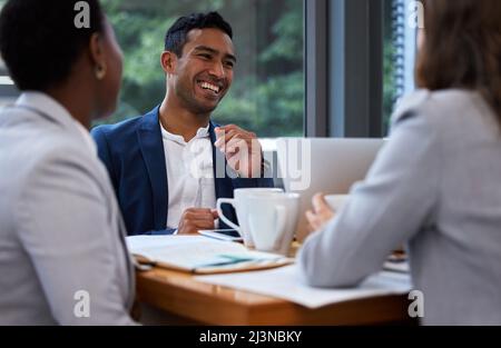 Die Geschwindigkeit des Chefs ist die Geschwindigkeit des Teams. Aufnahme einer Gruppe von Kollegen, die in einem modernen Büro ein Meeting und Frühstück abhalten. Stockfoto