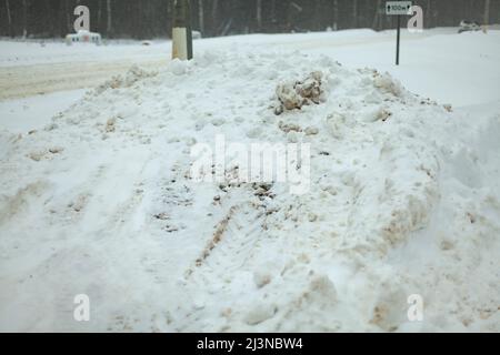 Schneeverwehung auf der Straße. Schneeverwehung der Strecke. Winter in Russland. Eisrutsche. Stockfoto