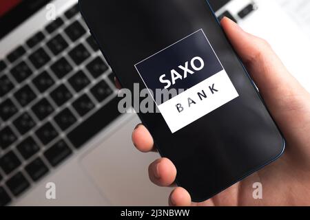 Poltava, Ukraine - 9. April 2022: Saxo Bank App. Händler und Broker Anwendung. Handy in der Hand Nahaufnahme Stockfoto