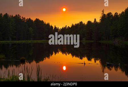 Ein Herbstuntergang über dem Brewer Lake im Algonquin Park, Kanada Stockfoto