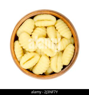 Rohe Gnocchi, italienische Knödel, in einer Holzschüssel. Aus kleinen Teigklumpen, mit Rippen in der Größe eines Daumens. Bestehend aus Kartoffeln und Weizenmehl. Stockfoto