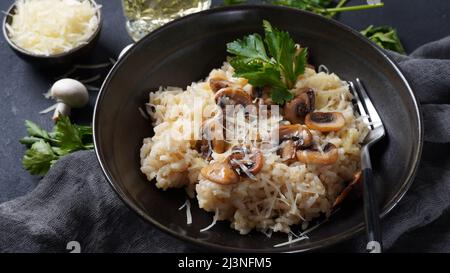 Pilzrisotto mit Petersilie und Parmesan garniert. Stockfoto