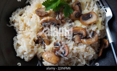 Pilzrisotto mit Petersilie und Parmesan garniert. Stockfoto