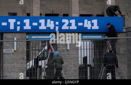 Berlin, Deutschland. 09. April 2022. Fußball: Bundesliga, Hertha BSC - 1. FC Union Berlin, Arbeiter setzen den letzten Schliff auf die Schilder über den Eingängen zum Olympiastadion. Kredit: Paul Zinken/dpa - ACHTUNG: Nur für redaktionellen Gebrauch und nur mit vollständiger Erwähnung des oben genannten credit/dpa/Alamy Live News Stockfoto