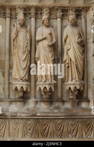 Papst Callixtus I. (links) und zwei Apostel von links nach rechts auf dem Südportal der Westfassade der Kathedrale von Reims (Cathédrale Notre-Dame de Reims) in Reims, Frankreich. Gotische Statuen auf der linken Seite des Südportals wurden nach 1252 datiert. Stockfoto