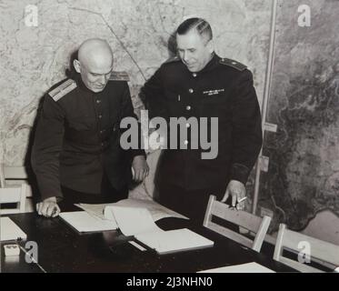 Der sowjetische General Ivan Susloparov (auch als Ivan Sousloparov geschrieben) und sein Dolmetscher Ivan Cherniaev (links) im Kartenraum, auch bekannt als der Kriegsraum des Obersten Hauptquartiers der alliierten Expeditionstruppe (SHAEF) im Museum der Kapitulation (Musée de la Reddition) in Reims, Frankreich, Am 6. Mai 1945. Das erste deutsche Kapitulationsinstrument, das den Zweiten Weltkrieg in Europa beendete, wurde am 7. Mai 1945 um 02:41 Uhr mitteleuropäischer Zeit (MEZ) auf diesem Tisch in diesem Raum unterzeichnet. Der historische Raum dient heute als Teil des Museums der Kapitulation (Musée de la Reddition). Das Schwarze und das Whi Stockfoto