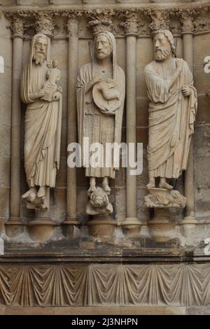 Der heilige Simeon, der heilige Johannes der Täufer, der Prophet Jesaja, dargestellt von links nach rechts auf dem Südportal der Westfassade der Kathedrale von Reims (Cathédrale Notre-Dame de Reims) in Reims, Frankreich. Gotische Statuen auf der rechten Seite des Südportals wurden vor 1220 datiert. Stockfoto