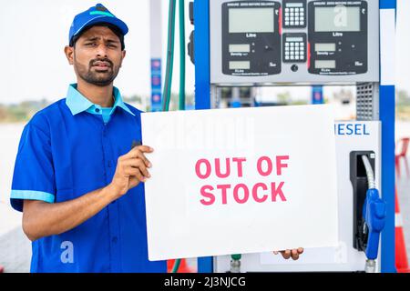 Arbeiter bei Benzin- oder Gasfüllung sation zeigt out of Stock Hinweisschild - Konzept der Wirtschaft und Kraftstoff-Krise Mangel. Stockfoto