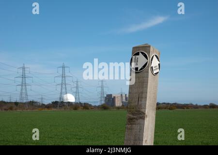 Fußwegschild mit Kernkraftwerk Sizewell in der Ferne, weicher Fokus Stockfoto