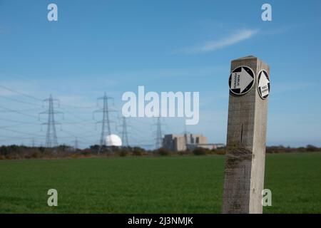 Fußwegschild mit Kernkraftwerk Sizewell in der Ferne, weicher Fokus Stockfoto