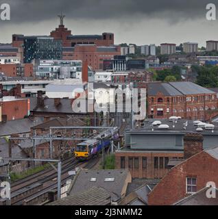 Der nördliche Zug der Klasse 144 fährt durch die Stadtlandschaft im Stadtzentrum von Leeds Stockfoto