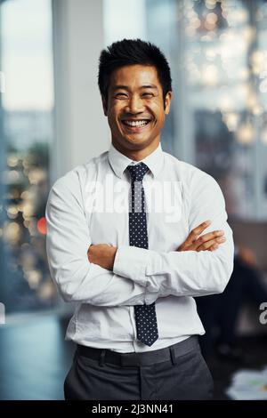 Investieren Sie täglich in Ihre Zukunft. Porträt eines gut gekleideten Geschäftsmanns, der in einem Büro steht. Stockfoto