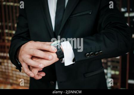 Armbanduhr an der Hand eines Mannes. Beobachten Sie die Hand eines Mannes in einer Jacke Stockfoto