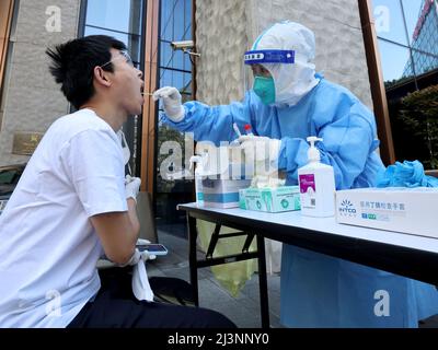 Shanghai, China. 9. April 2022. Ein medizinisches Personal nimmt eine Abstrichprobe eines Bewohners für Nukleinsäuretests an einem COVID-19-Teststandort in Shanghai, Ostchina, 9. April 2022. Quelle: Chen Jianli/Xinhua/Alamy Live News Stockfoto