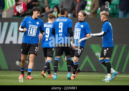 09. April 2022, Niedersachsen, Wolfsburg: Fußball: Bundesliga, VfL Wolfsburg - Arminia Bielefeld, Matchday 29, Volkswagen Arena. Die Spieler von Arminia Bielefeld tragen ein Trikot mit der Nummer 9 auf dem Rücken und der Aufschrift 'Get Well Soon Fabi' als Zeichen der Unterstützung für Fabian Klos, der eine schwere Kopfverletzung erlitten hat. Foto: Swen Pförtner/dpa - WICHTIGER HINWEIS: Gemäß den Anforderungen der DFL Deutsche Fußball Liga und des DFB Deutscher Fußball-Bund ist es untersagt, im Stadion und/oder vom Spiel aufgenommene Fotos in Form von Sequenzbildern und/oder Video-l zu verwenden oder zu verwenden Stockfoto