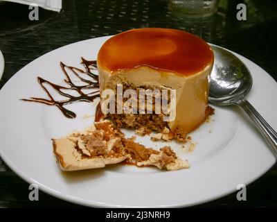 Ein Stück Wüstenkuchen auf einem Platz mit Silberlöffel in einem Restaurant Stockfoto