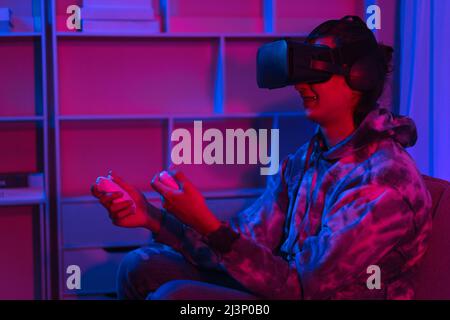 Metaverse Technologiekonzept, Mann spielt Spiele mit Virtual-Reality-Brille in Metaverse. Stockfoto
