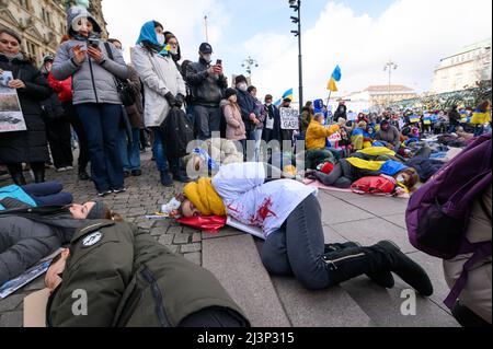 Hamburg, Deutschland. 09. April 2022. Demonstranten lügen und stehen während einer Protestaktion am Rathausmarkt. Mehrere hundert Menschen protestierten am Samstag in einer kraftvollen Aktion am Hamburger Rathausmarkt gegen den Krieg in der Ukraine. Einige der Demonstranten stellten die grausamen Bilder von Zivilisten nach, die in den Kiewer Vororten Butscha, Irpin und Hostomel getötet wurden: Wie Kriegsopfer, einige blutüberströmt und mit gefesselten Händen, legten sie sich auf den Platz vor dem Rathaus. Das Wehklagen der Sirenen war zu hören. Quelle: Jonas Walzberg/dpa/Alamy Live News Stockfoto