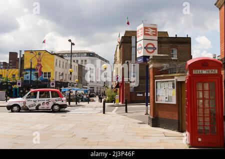 Das A-Taxi, das an einem Schild der Waterloo Station und einem K2-Telefonkasten an der Ecke Baylis und Spur Road, Waterloo, London, Großbritannien, vorbeifährt. 13 Juni 2009 Stockfoto