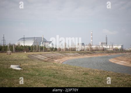 Tschernobyl, Ukraine. 10. April 2019. Die neue Schutzkonstruktion umfasst die Überreste der Reaktor Nummer 4 im Kernkraftwerk Tschernobyl, in der Katastrophe von Tschernobyl im Jahr 1986 zerstört. Die Anlage befindet sich jetzt in der Sperrzone von Tschernobyl in der Ukraine. Stockfoto