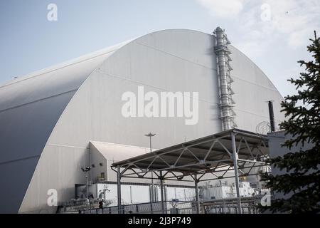 Tschernobyl, Ukraine. 10. April 2019. Die neue Schutzkonstruktion umfasst die Überreste der Reaktor Nummer 4 im Kernkraftwerk Tschernobyl, in der Katastrophe von Tschernobyl im Jahr 1986 zerstört. Die Anlage befindet sich jetzt in der Sperrzone von Tschernobyl in der Ukraine. Stockfoto