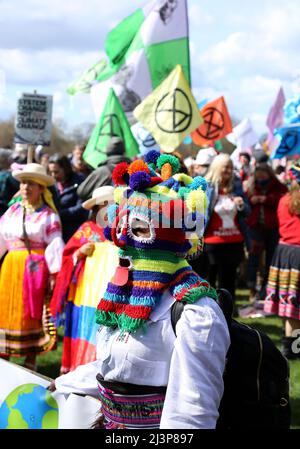 London, Großbritannien. 09. April 2022. Ein Protestler steht vor den Rebellion-Flaggen des Aussterbens und wartet darauf, dass der marsch im Rahmen ihrer einwöchigen Aktion gegen den Klimawandel beginnt. Hyde Park, London. April 9. 2022. Anna Hatfield/Pathos Credit: Pathos Images/Alamy Live News Stockfoto