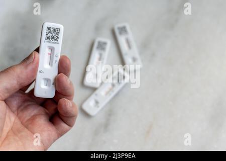 Selbst- oder selbst verabreichte laterale Schnellflusstests (Rapid lateral flow Tests, LFT) für COVID-19 Coronavirus, sowohl positiv als auch negativ; Hand mit negativem Ergebnis Stockfoto
