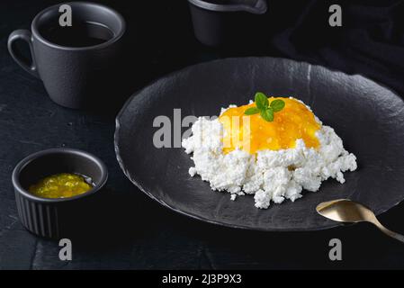 Zitronenmarmelade mit Quark in schwarzer Schüssel Nahaufnahme Stockfoto