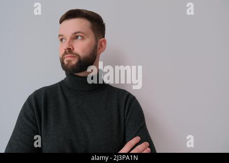 Porträt eines selbstbewussten Mannes in einem Pullover mit Polokragen. Erfolgreicher Geschäftsmann, Manager im lässigen Stil Stockfoto