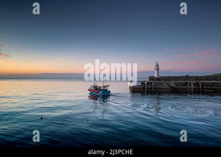 Kleines Fischerboot, das im Morgengrauen den Hafen von mevagissey, cornwall, verlässt und das ruhige Meer hat Stockfoto