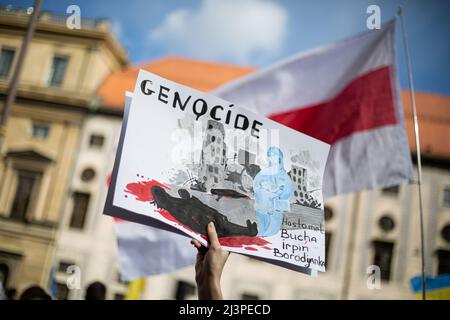 München, Deutschland. 09. April 2022. Schild vor der weißrussischen Flagge: " Genozid Hostomel, Bucha, Irpin, Borodyanka ". Am 9. April versammelten sich 2022 Menschen in München, Deutschland, um gegen die russische Invasion in der Ukraine zu protestieren und sich an die Toten des Massakers von Bucha zu erinnern. (Foto: Alexander Pohl/Sipa USA) Quelle: SIPA USA/Alamy Live News Stockfoto