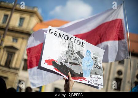 München, Deutschland. 09. April 2022. Schild vor der weißrussischen Flagge: " Genozid Hostomel, Bucha, Irpin, Borodyanka ". Am 9. April versammelten sich 2022 Menschen in München, Deutschland, um gegen die russische Invasion in der Ukraine zu protestieren und sich an die Toten des Massakers von Bucha zu erinnern. (Foto: Alexander Pohl/Sipa USA) Quelle: SIPA USA/Alamy Live News Stockfoto