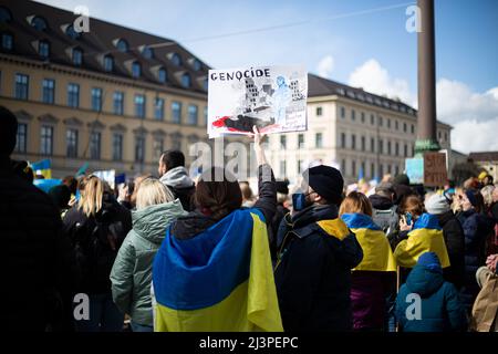 München, Deutschland. 09. April 2022. Zeichen: „ Genozid Hostomel, Bucha, Irpin, Borodyanka“. Am 9. April versammelten sich 2022 Menschen in München, Deutschland, um gegen die russische Invasion in der Ukraine zu protestieren und sich an die Toten des Massakers von Bucha zu erinnern. (Foto: Alexander Pohl/Sipa USA) Quelle: SIPA USA/Alamy Live News Stockfoto