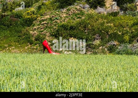 Eine rote, überlebensgroße, Stiletto-Heel-Schuhkunstinstallation für Frauen in einer agrarischen Landschaft im Santa Barbara County, Kalifornien. Stockfoto