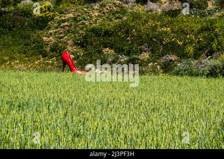 Eine rote, überlebensgroße, Stiletto-Heel-Schuhkunstinstallation für Frauen in einer agrarischen Landschaft im Santa Barbara County, Kalifornien. Stockfoto