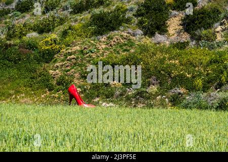 Eine rote, überlebensgroße, Stiletto-Heel-Schuhkunstinstallation für Frauen in einer agrarischen Landschaft im Santa Barbara County, Kalifornien. Stockfoto