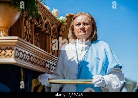 Eine Frau aus einer Bruderschaft trägt einen Wagen, der eine Szene aus der Ostergeschichte darstellt. In Spanien heißt die Karwoche „Semana Santa“ und itís wird mit unvergleichlicher Pracht und Emotion gefeiert. Es kommt mit religiösen Prozessionen im ganzen Land, die die Straßen mit dem Beat der Trommeln, Blumen und religiösen Skulpturen füllen. Stockfoto