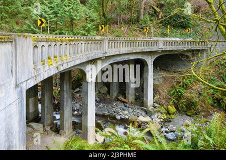 Landschaftlich schöner Chuckanut Drive, der über Oyster Creek auf einer Brücke mit einer scharfen Biegung im westlichen Bundesstaat Washington führt Stockfoto