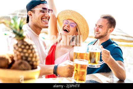 Junge trendige Freunde genießen Bier an der Strandbar Chiringuito - Sommerurlaub Lifestyle-Konzept mit glücklichen Menschen genießen Zeit zusammen an sonnigen Tag Stockfoto