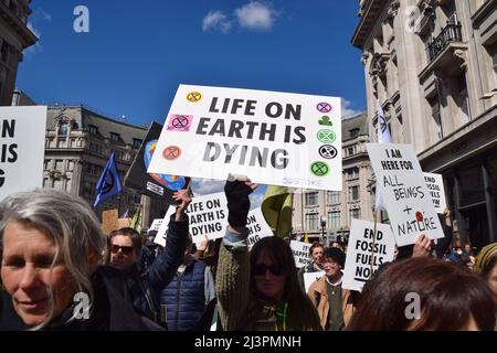 London, Großbritannien. 9.. April 2022. Ein Protestler hält ein Plakat mit dem Titel „das Leben auf der Erde stirbt“ in der Regent Street. Tausende von Rebellion-Demonstranten marschierten durch das Zentrum von London und blockierten die Straßen und forderten die Regierung auf, fossile Brennstoffe zu beenden und gegen den Klimawandel zu handeln. Kredit: Vuk Valcic/Alamy Live Nachrichten. Stockfoto