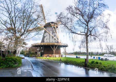 Weesp, Niederlande. 09 april 2022. Windmühle 'de Vriendschap' entlang des Utrechtse-Weges und des Flusses Vecht, mit rotationg Klingen. Die Gilde der freiwilligen Millers wird 2022 50 Jahre alt. Um die Bedeutung des Müllerhandwerks zu unterstreichen, wurde ein Rekordversuch unternommen, alle niederländischen rotierenden Wind- und Wasserturbinen in den Niederlanden zwischen 11:00 und 12:00 Uhr gleichzeitig laufen zu lassen. Mehr als 800 Mühlen nahmen daran Teil, darunter 29 Mühlen im Ausland. Kredit: Steppeland/Alamy Live Nachrichten Stockfoto