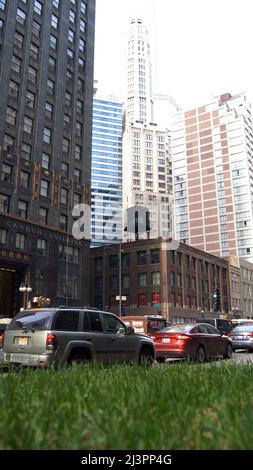 CHICAGO, ILLINOIS, USA - 11. DEZ 2015: Urbane Canyons zwischen Wolkenkratzern in der Innenstadt, mit Autos im Vordergrund Stockfoto