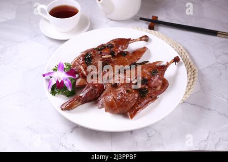 Gesalzene gebratene Ente in einem Gericht mit Blick auf den Tee auf grauem Hintergrund singapurs Essen Stockfoto