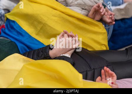 Whitehall, London, Großbritannien. 9. April 2022. Die Demonstranten demonstrierten gegen den Tod von ukrainischen Zivilisten während des Krieges mit Russland, indem sie tot spielten, wobei einige ihre Hände hinter dem Rücken hatten und nachstellten, wie einige Leichen auf den Straßen gefunden wurden Stockfoto