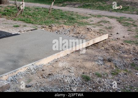 Fundamentschalung mit Zement gefüllt. Der Prozess des Baus des blinden Bereichs des Grundbaus des Hauses. Betonfundament für altes Haus. Stockfoto
